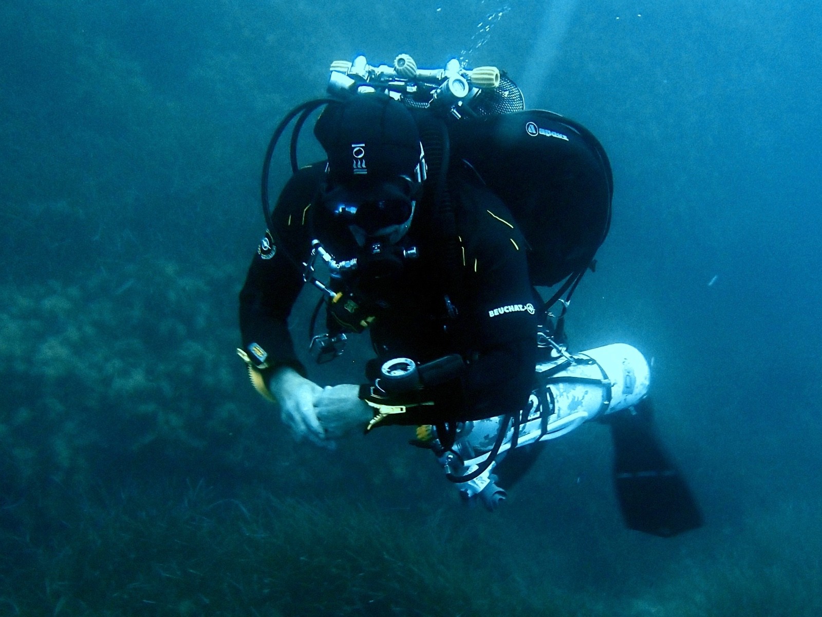 Tec diver with a stage cylinder hovering above a seagrass meadow
