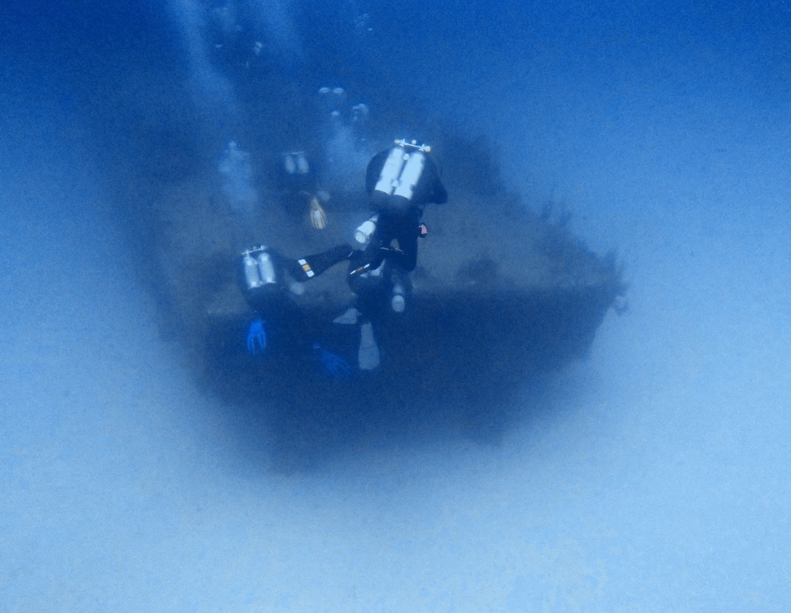 Group of tec divers gathered near the bow of a large wreck